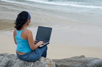 Businesswoman with laptop computer on the beach