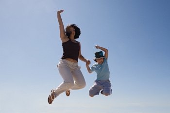 Mother and son jumping a over sky background