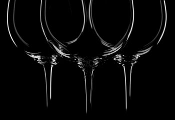 three wine glasses on black background, backlited