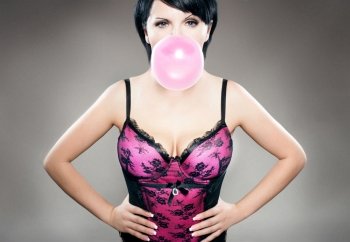 sexy brunette in pink lingerie playing with bubble gum