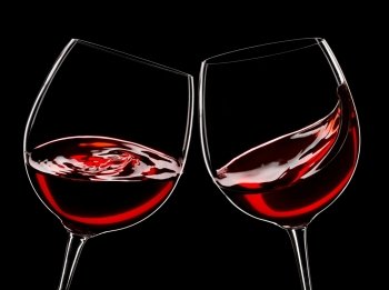 two glasses of red wine, isolated over black