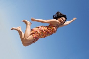 Beautiful girl flying a over sky background