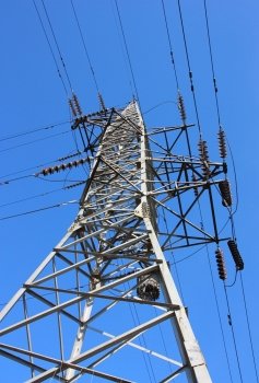 The high voltage post against the blue sky