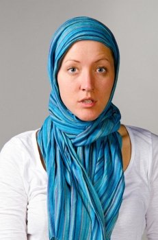 young beautiful caucasian woman in scarf on grey background