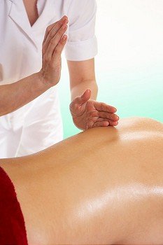 Woman with tattoo having back massage