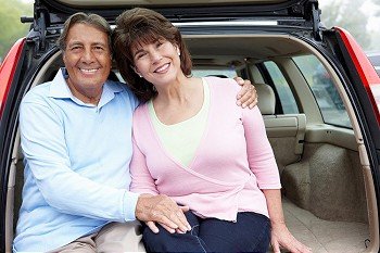 Senior Hispanic couple outdoors with car