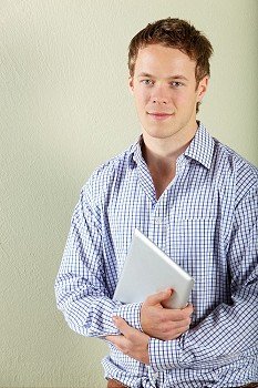 Studio Shot Of Young Man Holding Tablet Computer