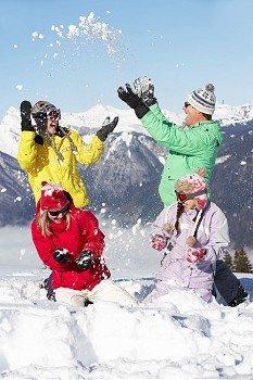 Teenage Family Having Snow Fight In Mountains