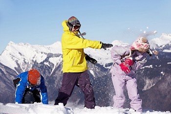 Teenage Family Having Snow Fight In Mountains