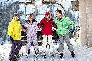Teenage Family Getting Off chair Lift On Ski Holiday In Mountains