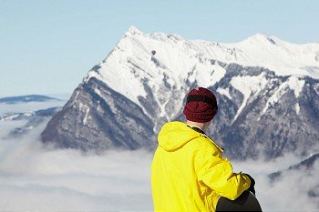 Teenage Snowboarder Admiring Mountain View Whilst On Ski Holiday In Mountains