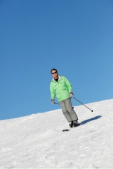 Man On Ski Holiday In Mountains