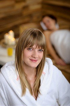 Close -up of young woman in bathrobe sitting at luxury spa