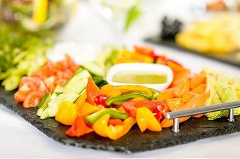Selection of fresh vegetables with dips on serving tray