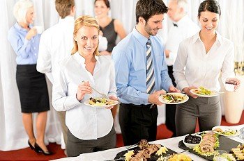 Business colleagues serve themselves at buffet catering service company event