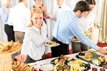 Business woman serve herself at buffet catering service company event