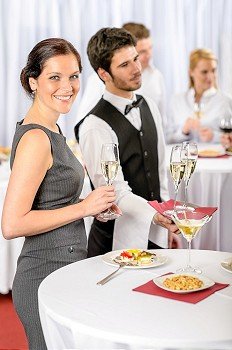Catering service at business meeting offer champagne aperitif to woman