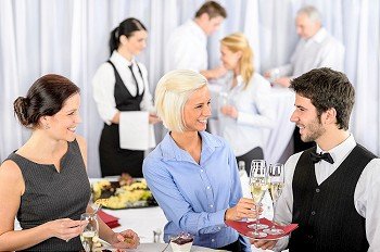 Business woman take aperitif from waiter during company seminar meeting