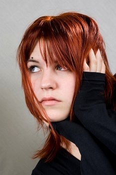 Cute redhead girl looking away. With messy hair.  Studio shot.