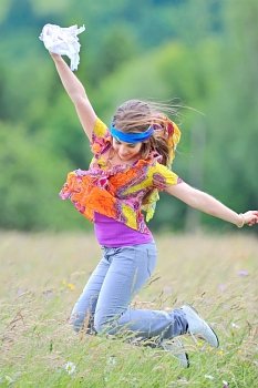 Jumping girl against summer meadow