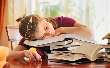 teenager girl sleeping on books