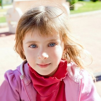 Blond little girl blue eyes portrait with pink winter sweater