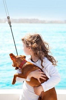 brunette kid girl with dog on the sea view from a boat