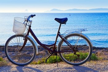 Bicycle in formentera beach on Balearic islands with Ibiza sunset background