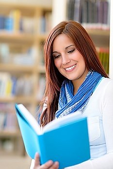Female high school student at library reading book