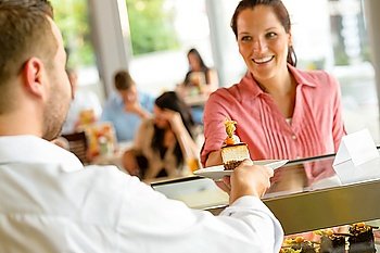 Waiter giving woman cake plate at cafe happy man service