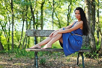 Young woman sitting on the bench in park
