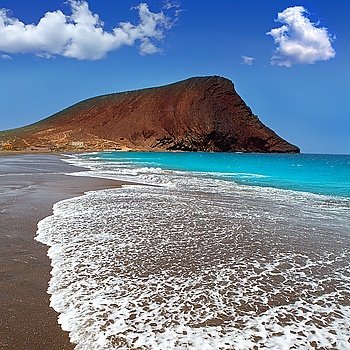 Beach Playa de la Tejita turquoise in Tenerife Canary islands with red mountain
