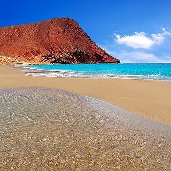 Beach Playa de la Tejita turquoise in Tenerife Canary islands with red mountain