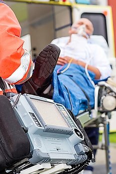 Emergency defibrillator patient with oxygen mask on ambulance stretcher