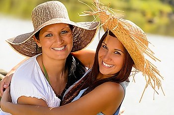Mother and daughter hugging outdoors summer teen vacation straw hats