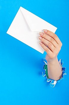 Hand holding paper envelope from hole