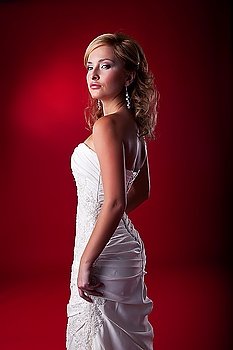 Fiancee - beautiful blonde wedding model in bridal white dress standing on podium