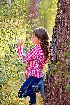 beautiful kid girl profile looking plants in pine forest outdoor