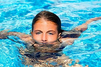 beautiful blue eyes kid girl at the pool with face in water surface