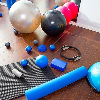Aerobic Pilates stuff like mat balls roller magic ring rubber bands on wooden floor