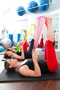 Aerobics pilates women group with rubber bands in a row at fitness gym