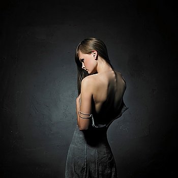 beautiful woman in sexy evening dress against dark background