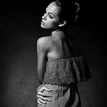 Black and white art photo. Elegant lady on dark background