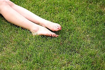 bare legs of the women laying on green grass
