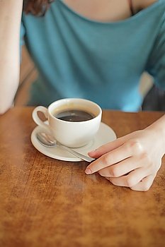 Cup of coffee in the women´s hand on table