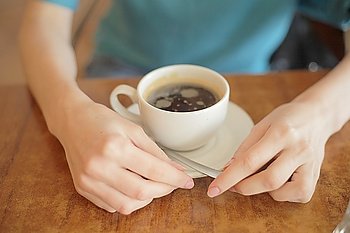 Closeup of female hands holding a mug. Selective focus on hands and fingers.