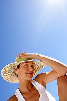 Woman in a straw hat against a blue sky
