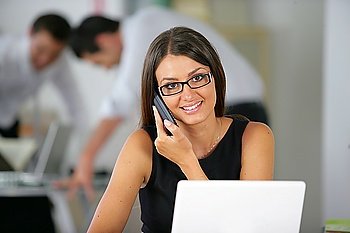 Friendly office worker with a phone and laptop