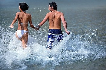 Couple running into the sea