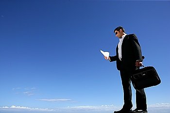 Businessman with a briefcase against a blue sky